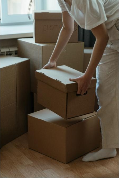 Person packing belongings into cardboard boxes